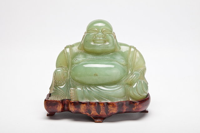 Appraisal: A CHINESE PEA-GREEN JADE CARVING OF A SEATED SMILING PUTAI