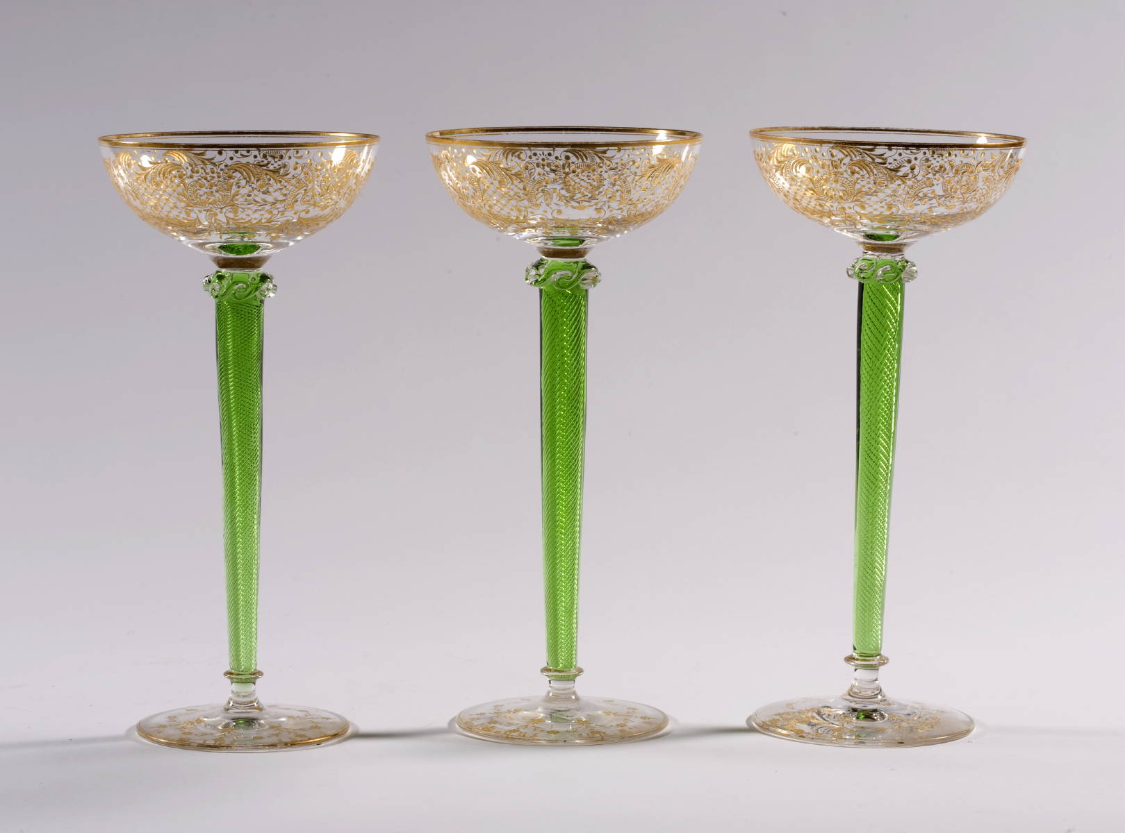 Appraisal: SEVEN EUROPEAN GLASS CHAMPAGNES WITH GREEN TWIST STEMS AND GILT