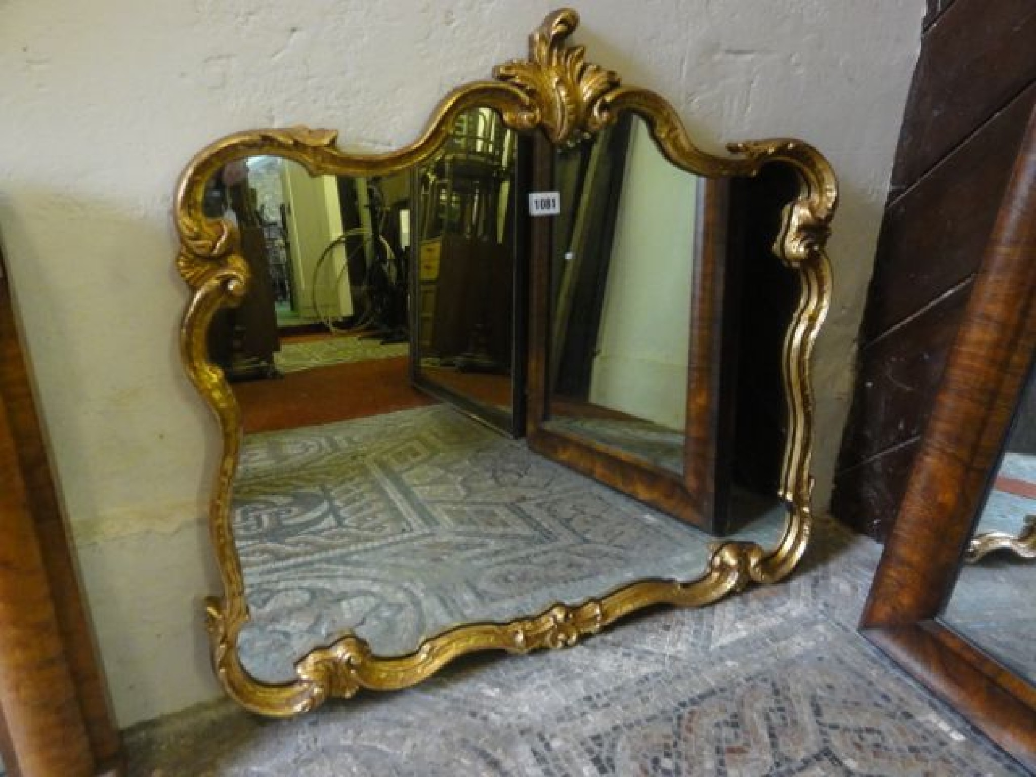 Appraisal: A contemporary rococo style gilt framed wall mirror with scrolling