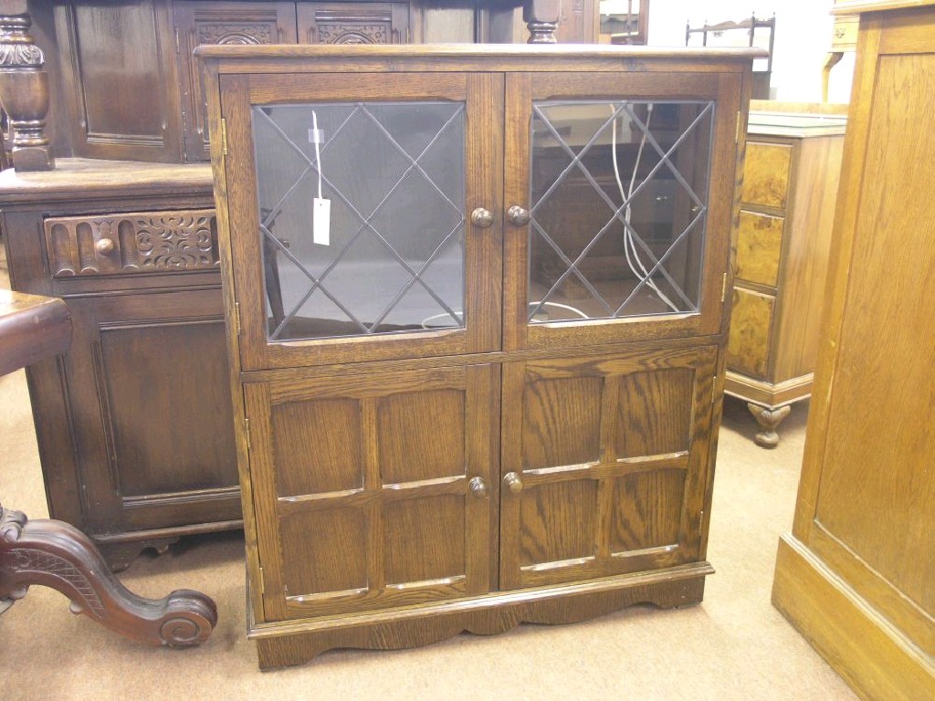 Appraisal: A reproduction dark oak display cabinet single shelf enclosed by