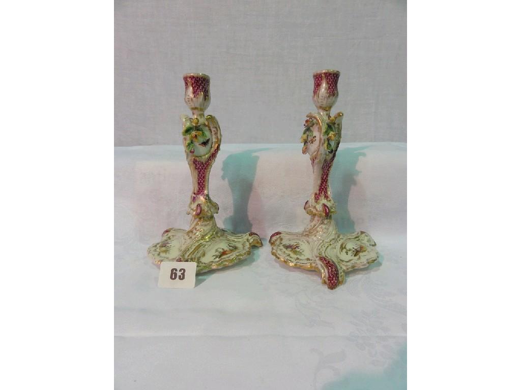 Appraisal: A pair of th century candlesticks of scrolling form probably