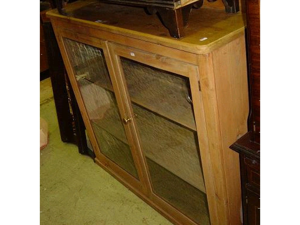 Appraisal: A stripped pine bookcase enclosed by a pair of glazed