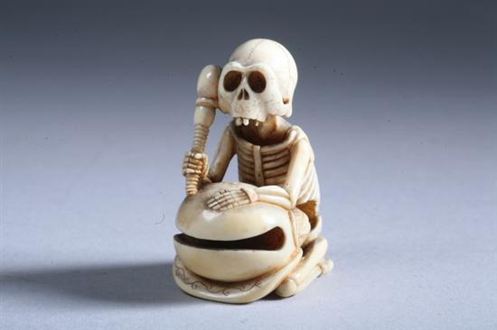 Appraisal: JAPANESE IVORY NETSUKE OF SKELETON AND DRUM - in high