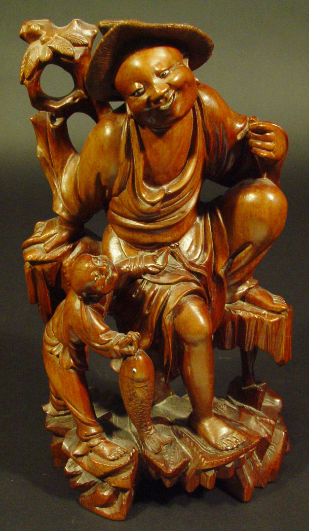 Appraisal: Oriental hardwood carving of two figures one clutching a fish