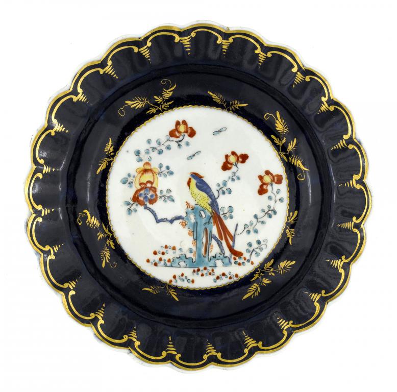 Appraisal: A FIRST PERIOD WORCESTER GROS BLEU GROUND FLUTED PLATE enamelled