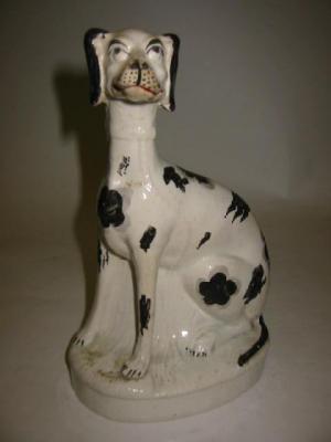 Appraisal: A VICTORIAN STAFFORDSHIRE POTTERY MODEL OF A LURCHER seated with