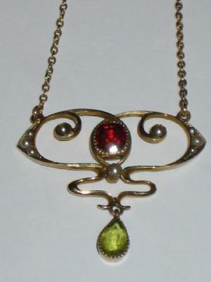 Appraisal: AN ART NOUVEAU GARNET AND PERIDOT PENDANT with central cushion