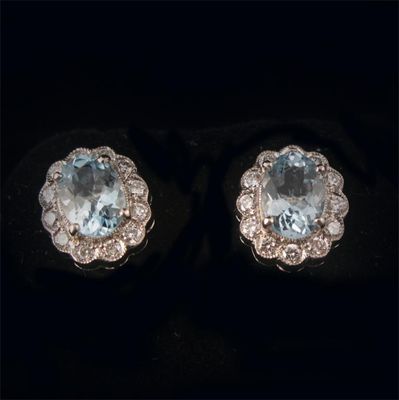 Appraisal: A pair of aquamarine and diamond cluster earrings the oval