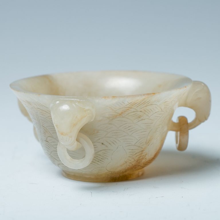 Appraisal: CELADON JADE 'RAMS HEAD' CUP Of globular body rising to