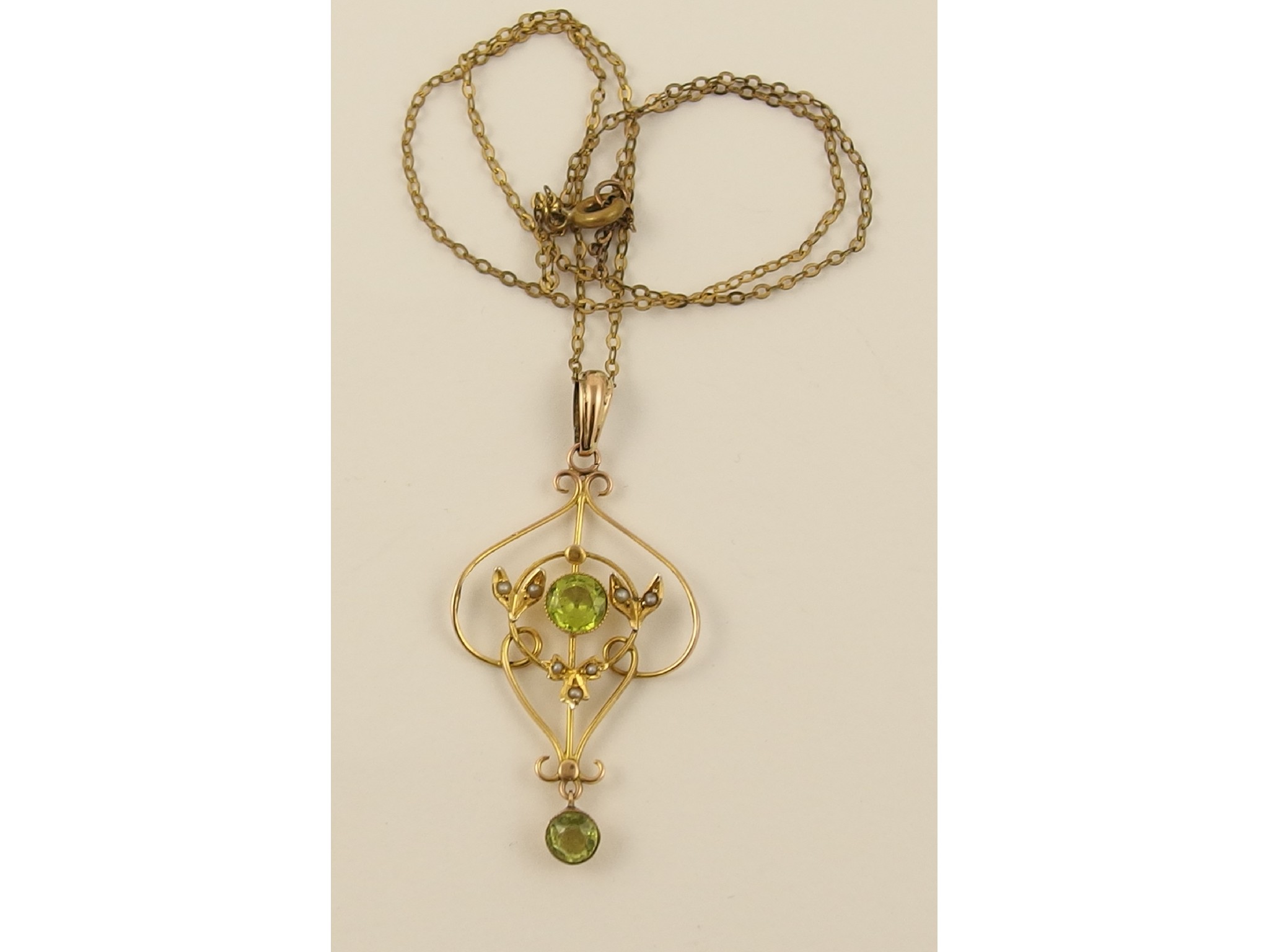 Appraisal: An Edwardian yellow metal peridot and pearl set pendant with