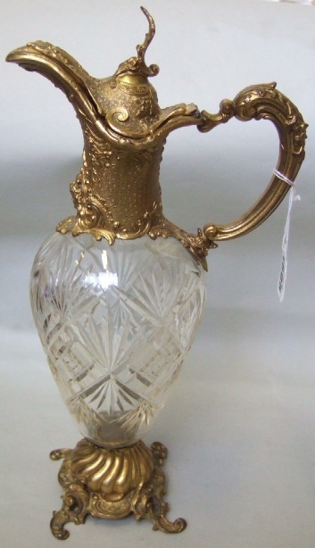 Appraisal: A cut glass claret jug with gilt metal scroll work