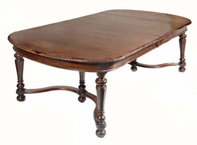 Appraisal: AN OAK EXTENDING DINING TABLE with carved edge and bowed