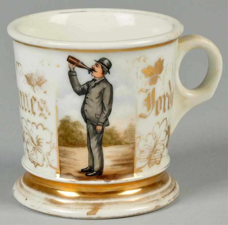 Appraisal: Man Drinking from Bottle Shaving Mug Description Gilt name James