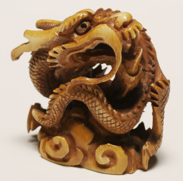 Appraisal: Japanese ivory netsuke serpent dragon coiled mythical beast on swirling