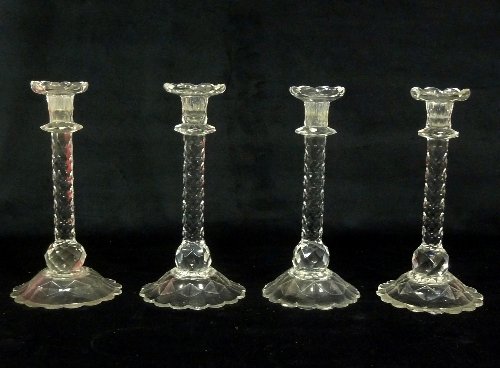 Appraisal: Four cut glass candlesticks with faceted stems and serrated borders