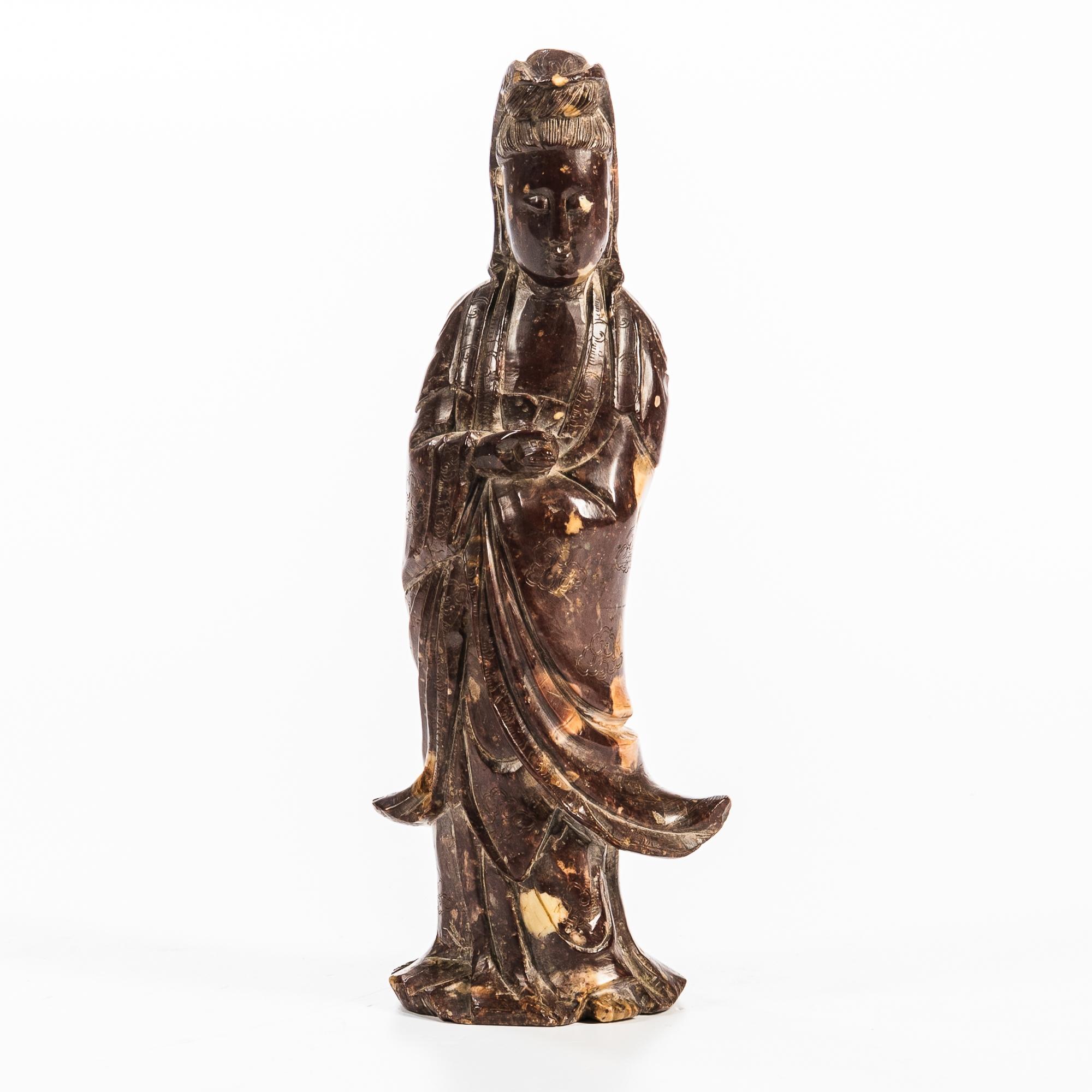 Appraisal: MOTTLED PURPLE SOAPSTONE FIGURE OF GUANYIN China standing with her