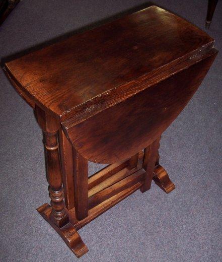 Appraisal: An oak oval two-flap table on gate type supports with