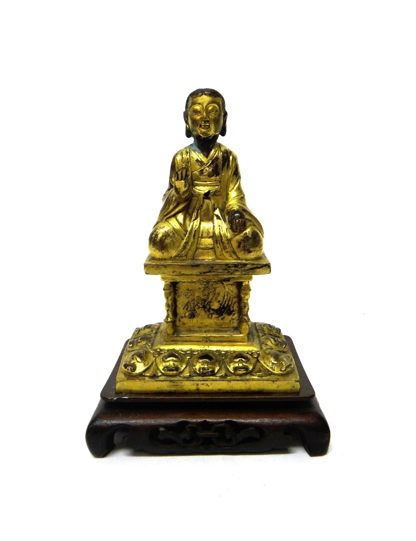 Appraisal: A gilt-metal figure of Buddha seated with right hand raised