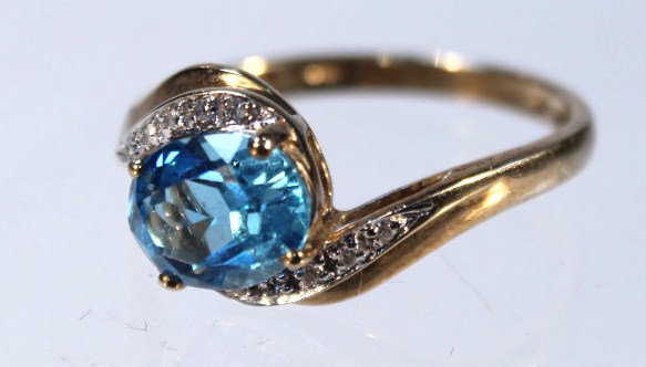 Appraisal: A dress ring with claw set central blue stone flanked