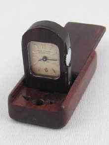 Appraisal: A miniature travelling clock in wooden case the dial signed