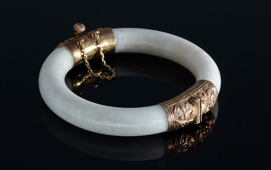 Appraisal: NEPHRITE JADE BANGLE BRACELET Exotic hinged bracelet with engraved gold