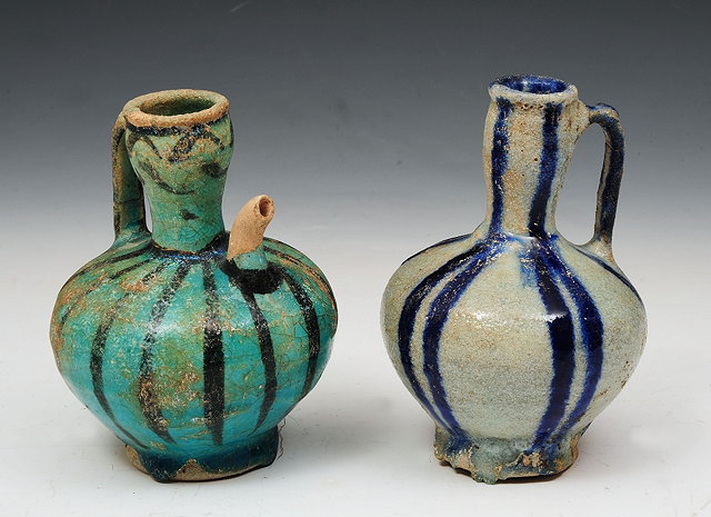 Appraisal: TWO KASHAN POTTERY JUGS one of turquoise ground the other