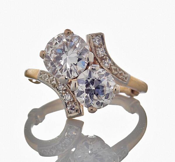 Appraisal: A twin stone diamond by-pass ring centering a round brilliant-cut