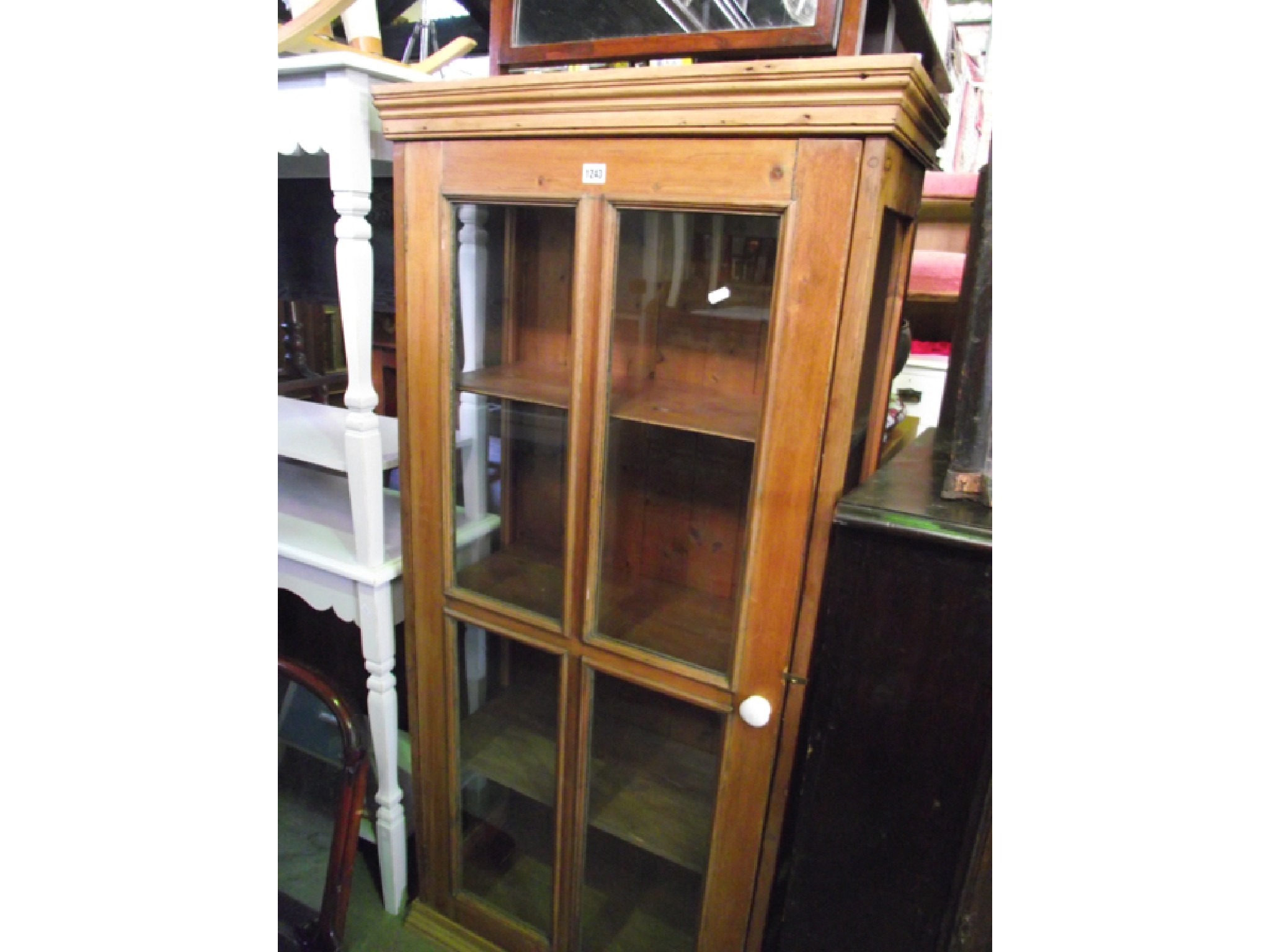 Appraisal: A th century stripped and waxed pine display cabinet with