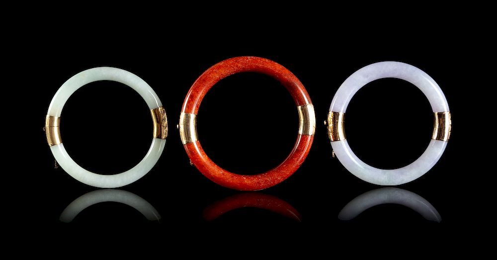 Appraisal: Three Jadeite and Hardstone Circular Bangles Largest interior diam in