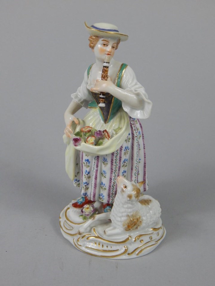 Appraisal: A Meissen figure of a shepherdess playing a pipe beside