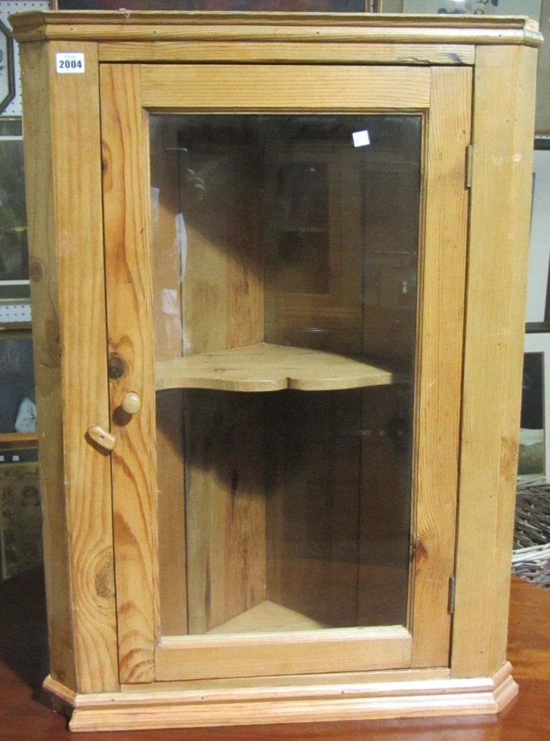 Appraisal: A pine hanging corner cupboard with glazed door