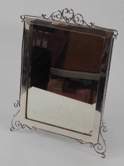 Appraisal: A George VI silver strut mirror with scrolling heart surmount