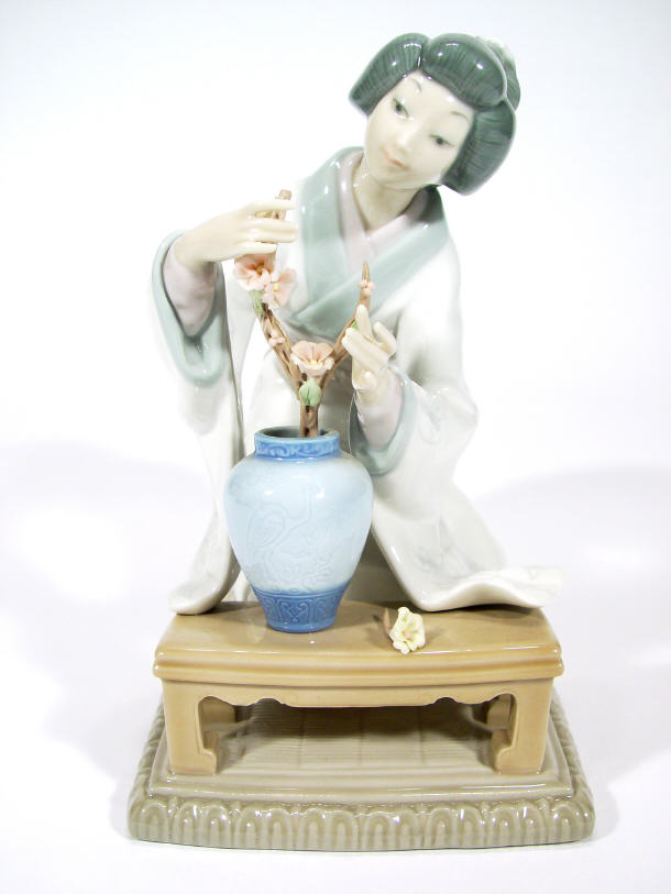 Appraisal: Lladro porcelain geisha girl arranging flowers in a vase printed