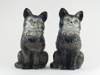 Appraisal: A pair of pottery black cats with glass eyes gilt