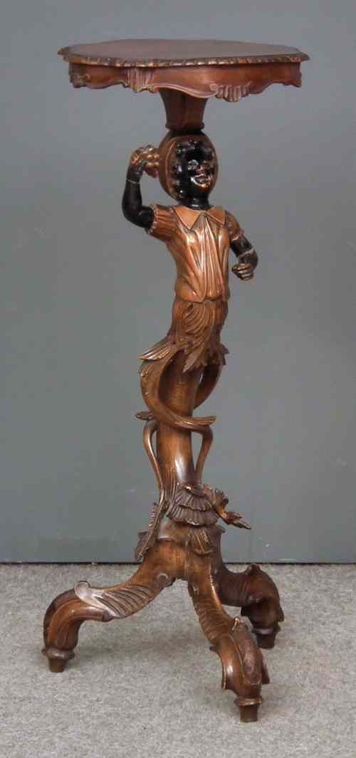 Appraisal: An Italian stained and ebonised carved walnut torchere with ''Blackamoor''