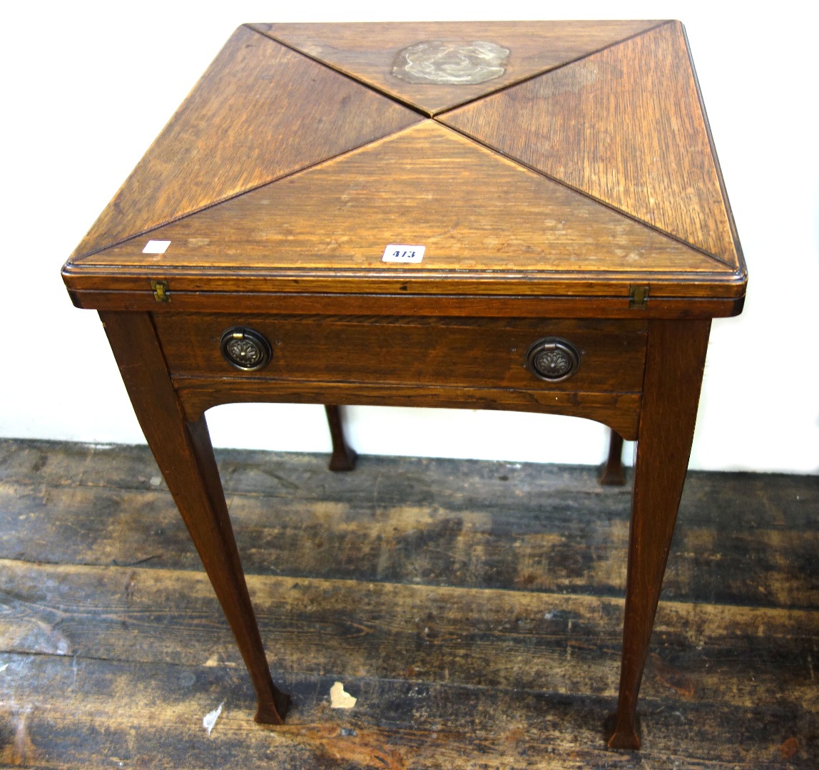 Appraisal: An Art Nouveau oak envelope top card table with frieze