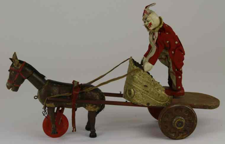 Appraisal: SCHOENHUT CLOWN ON CHARIOT Red stained wooden framework chariot embellished