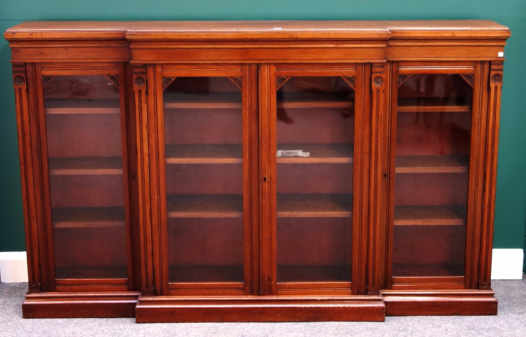 Appraisal: A Victorian walnut breakfront glazed four door bookcase on plinth