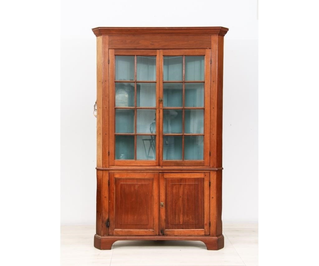 Appraisal: Pennsylvania walnut two-piece corner cupboard circa with molded cornice above