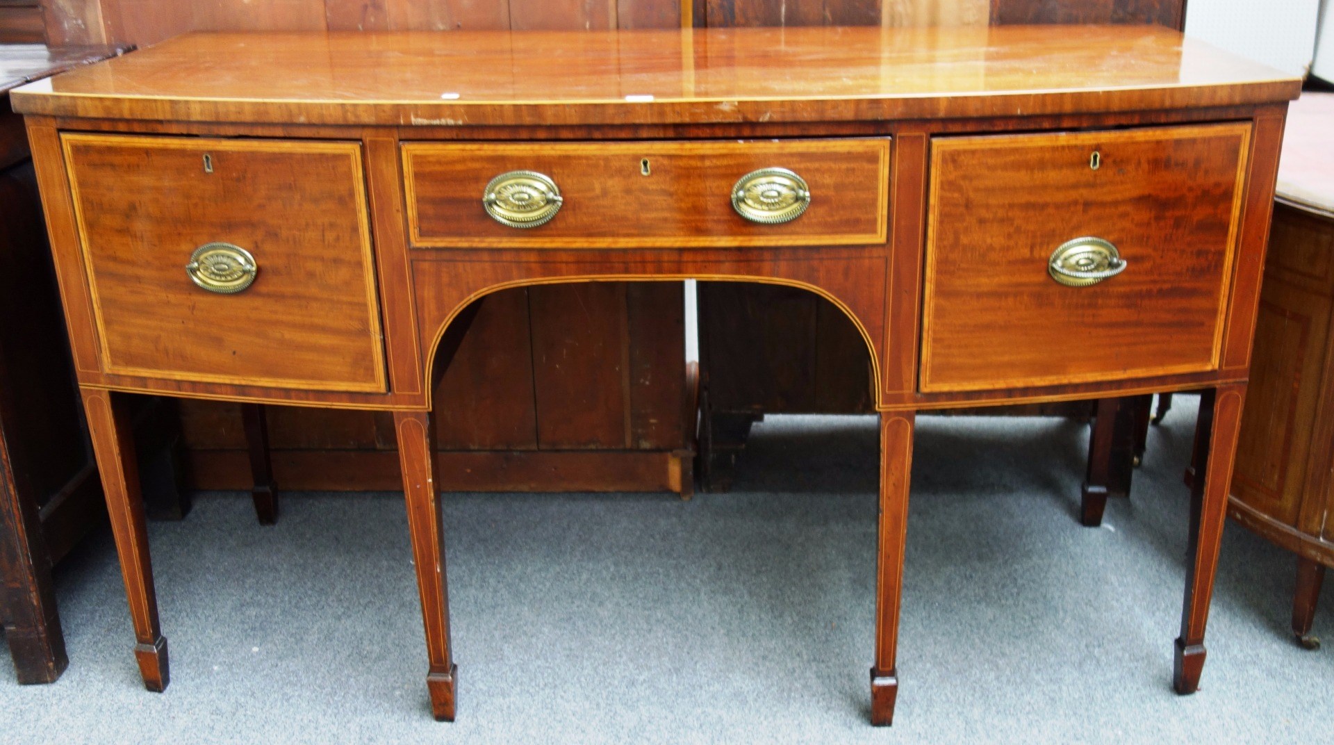 Appraisal: A George III satinwood banded mahogany bowfront sideboard with three