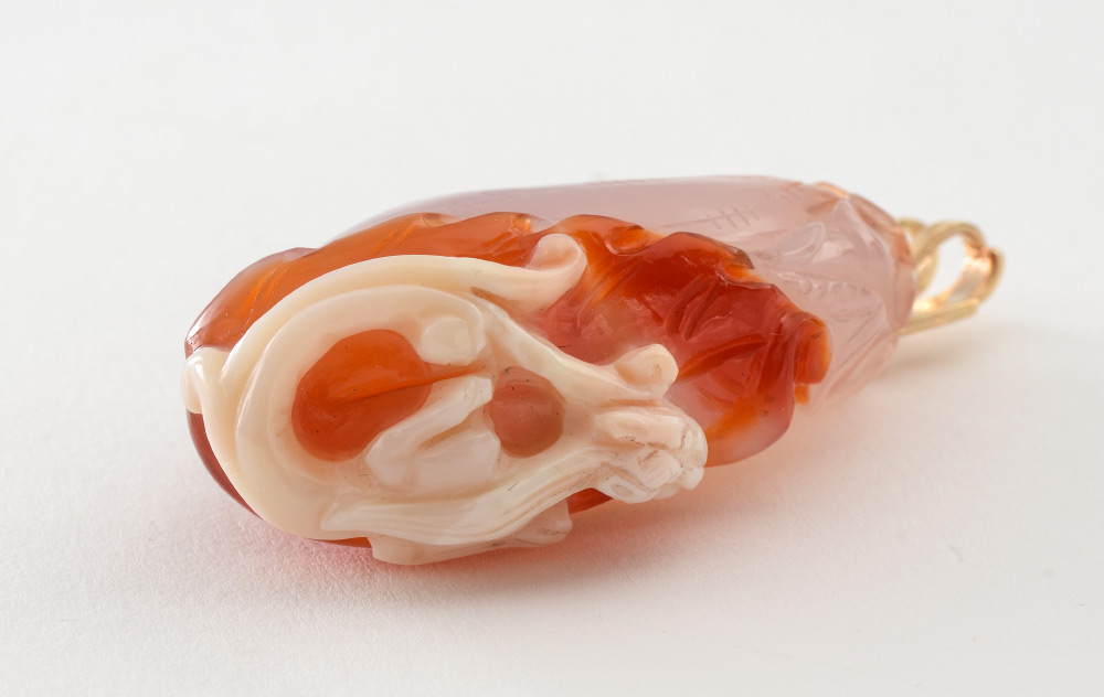 Appraisal: CARVED JADE PENDANT Carved red white jadeite pendant depicting flower