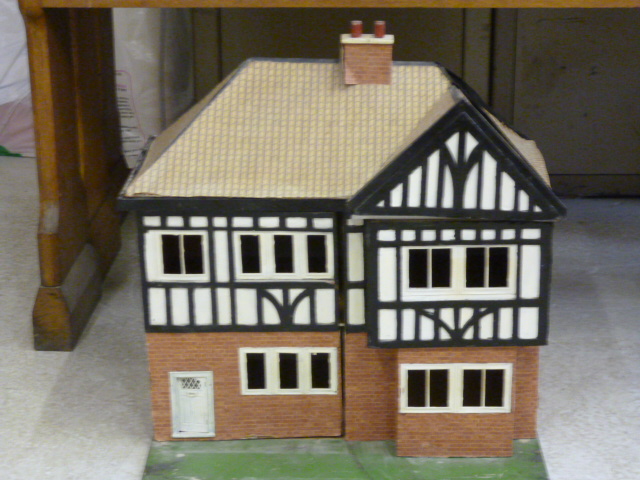 Appraisal: A scratch built doll's house timber painted and papered construction