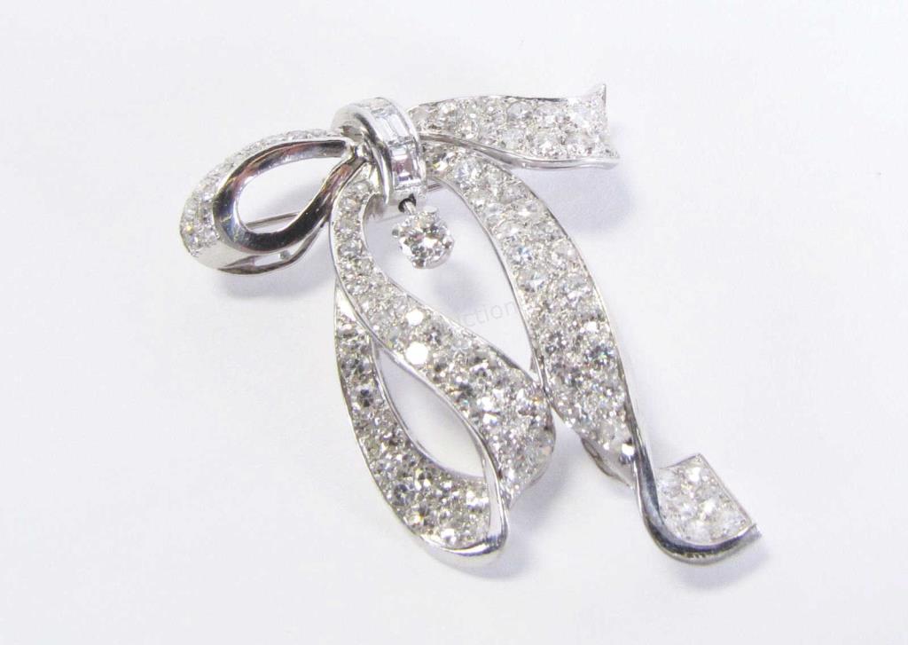 Appraisal: A platinum ribbon design brooch pendant with approximately ninety-four round