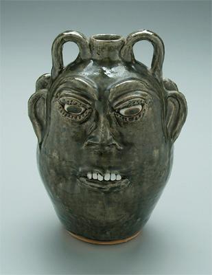 Appraisal: Cleater Meaders double face jug runny light olive glaze ceramic