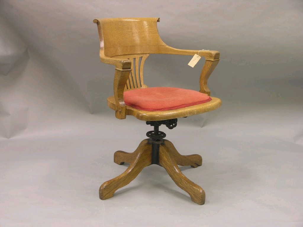 Appraisal: An Edwardian oak revolving desk chair with pierced splat and