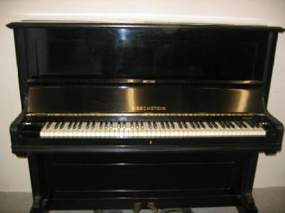 Appraisal: A BECHSTEIN UPRIGHT PIANO in walnut case with panelled fascia