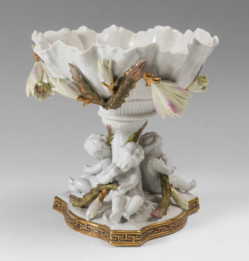 Appraisal: CONTINENTAL FIGURAL PUTTI PORCELAIN COMPOTE Scalloped bowl with applied floral