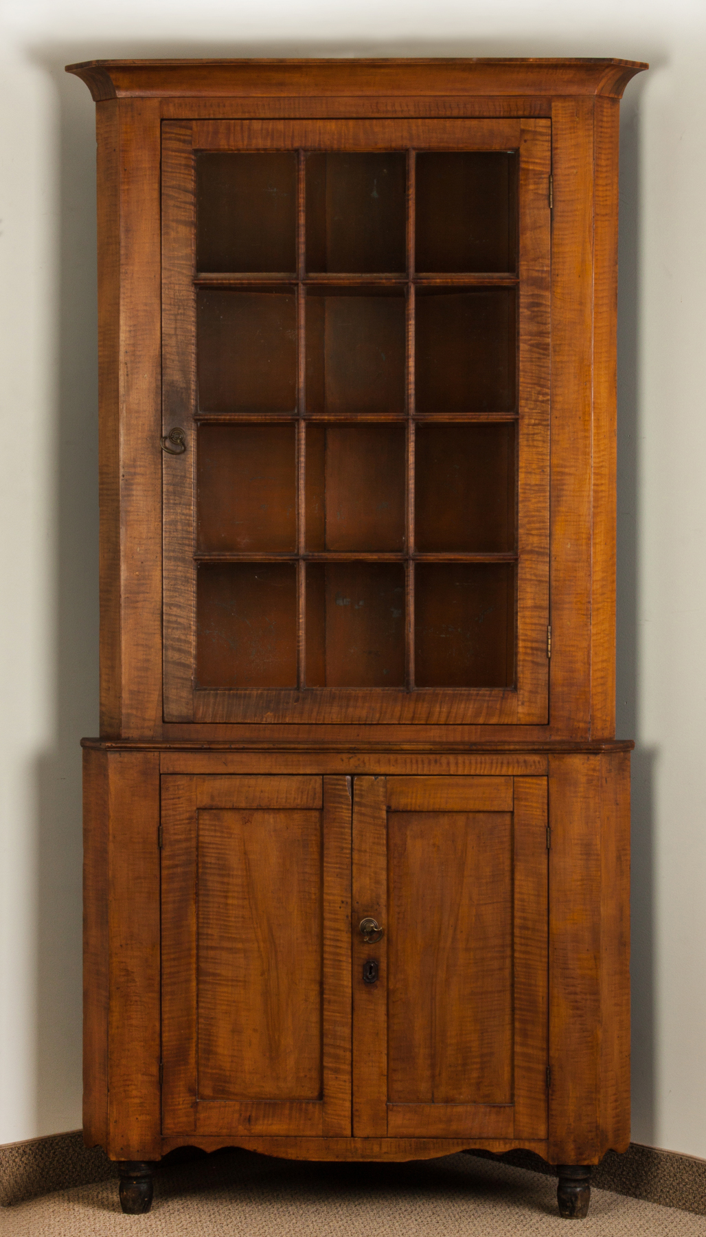 Appraisal: Pennsylvania Two-Piece Tiger Maple Corner Cupboard Early th century Shaped