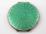 Appraisal: A silver compact with guilloche enamelled green lid and engine