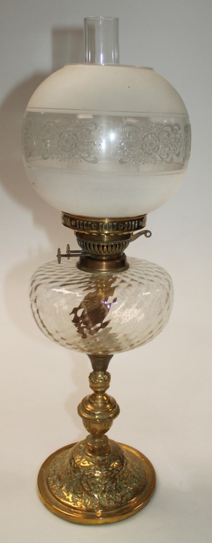 Appraisal: An Edwardian brass oil lamp with clear glass funnel and